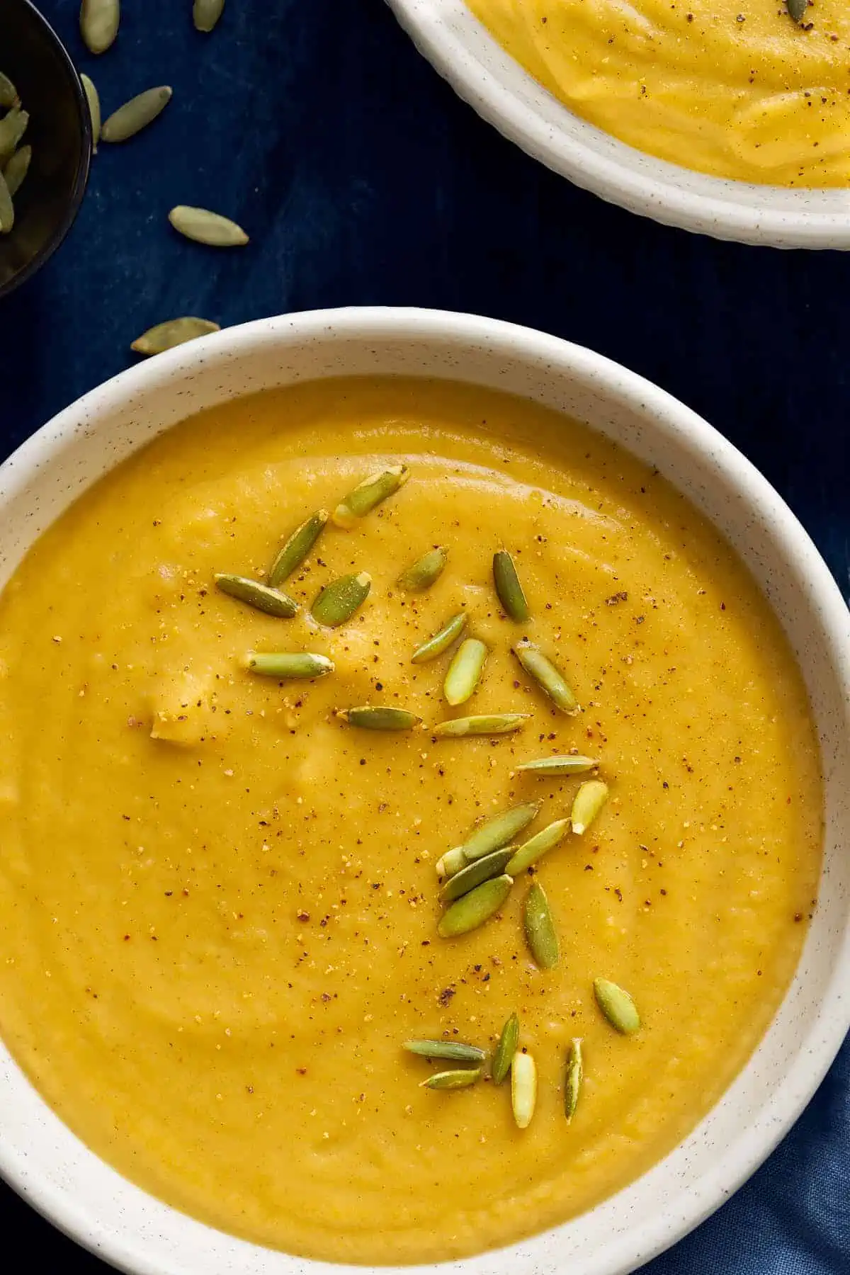 Creamy and delicious instant pot acorn squash soup garnish with pumpkin seeds.