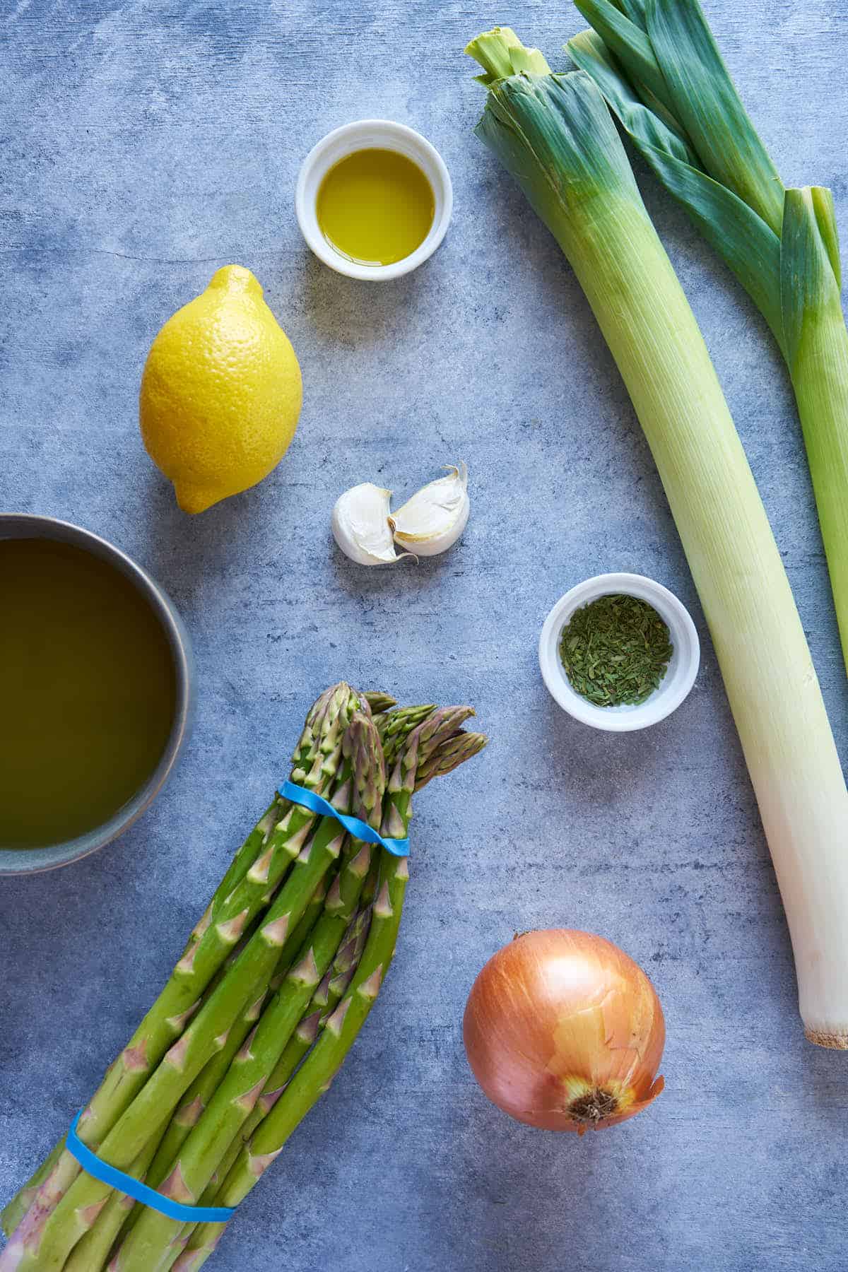 Ingredients to make green soup.  leeks, garlic, tarragon, onion, and broth.