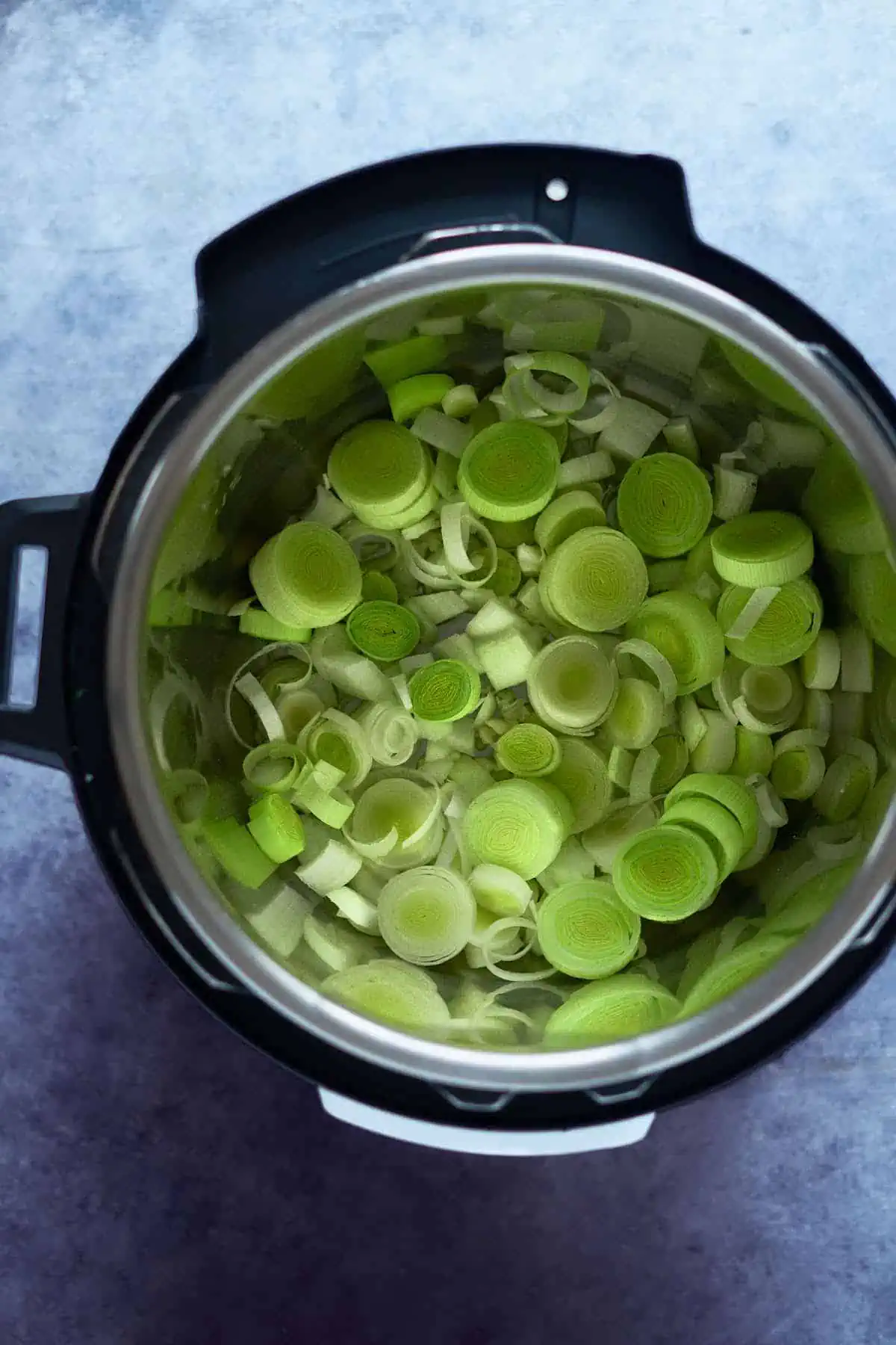 Leeks and onion inside the instant pot inner pot.