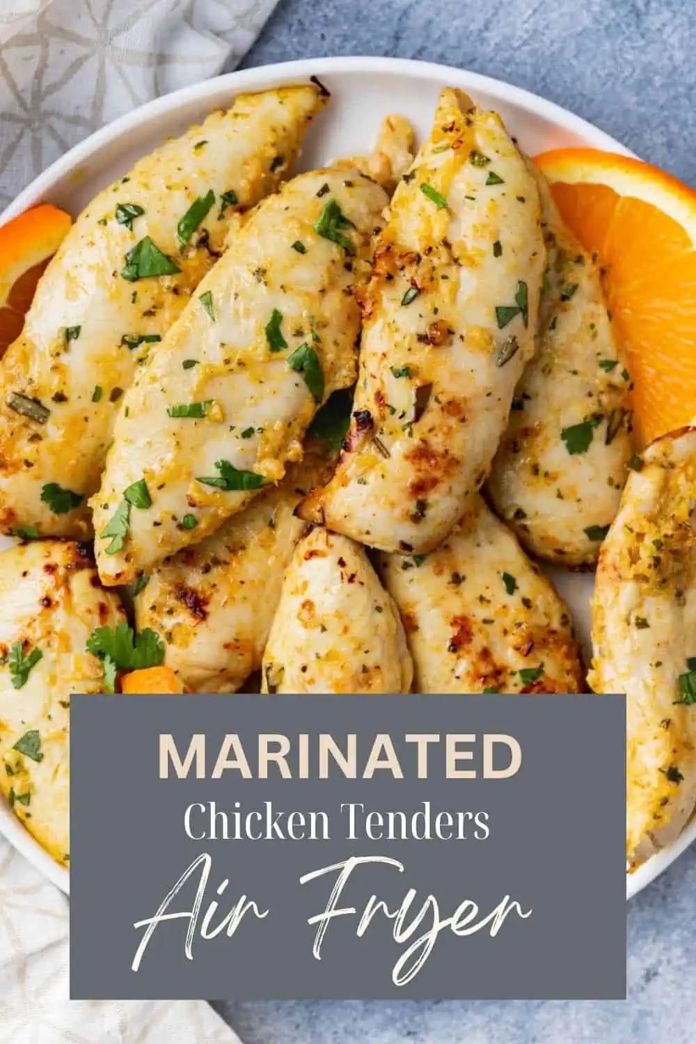 Marinated chicken tenders in an air fryer sprinkled with fresh herbs.