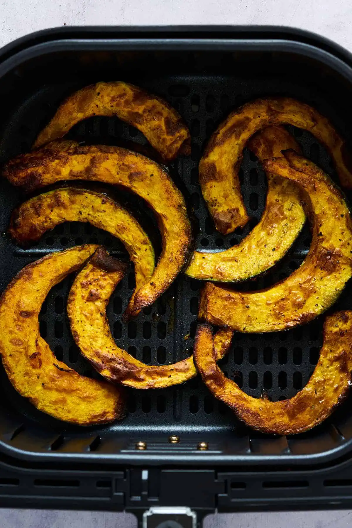 Air fryer buttercup squash in the air fryer basket after cooking.