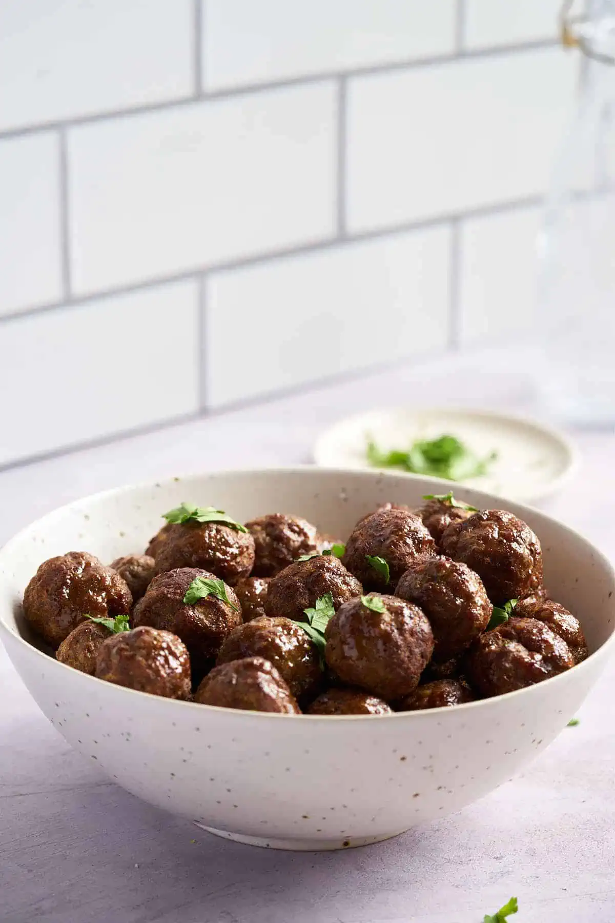 Air-fried meatballs in a bowl garnished with parsley.