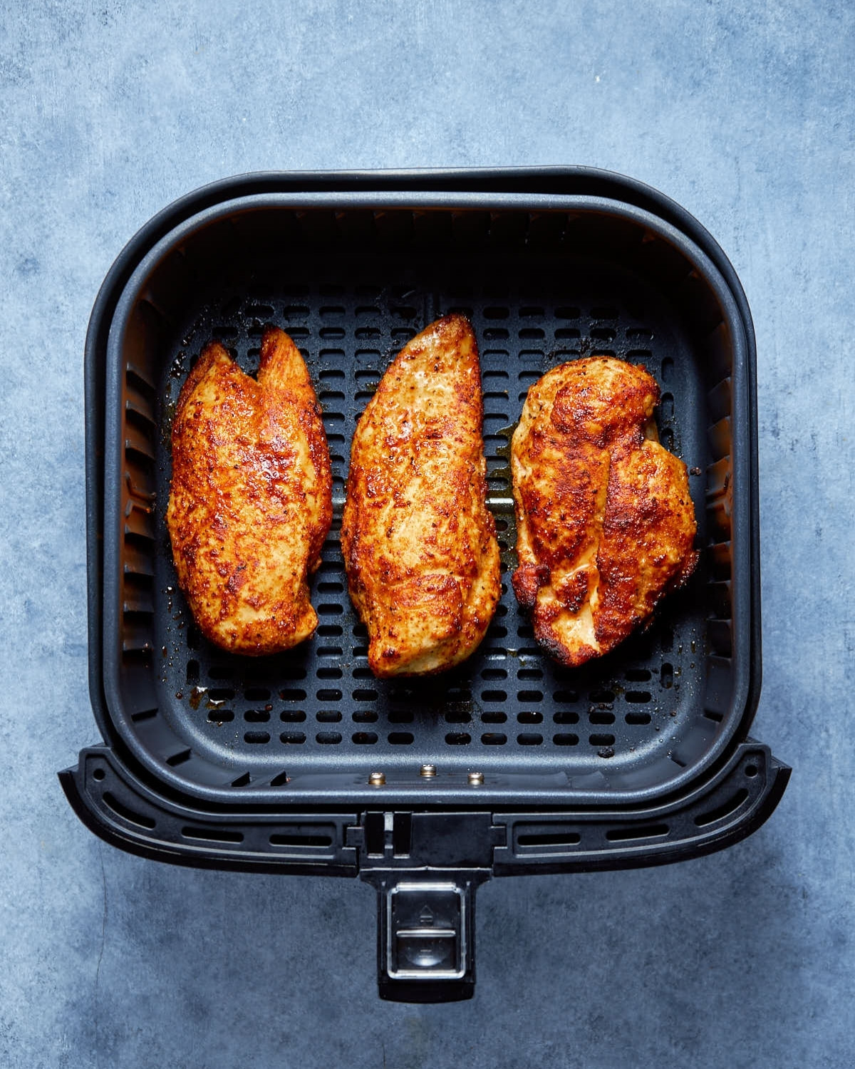 air fryer chicken breast in basket cooked evenly top view.