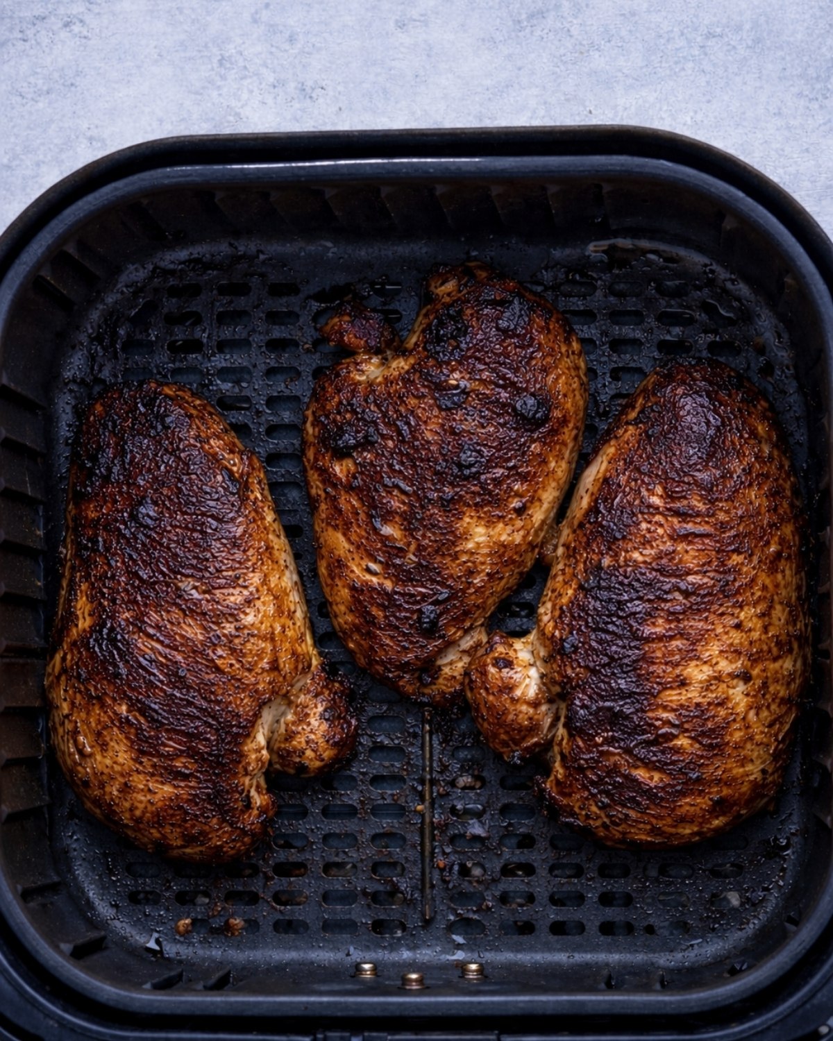 unevenly cooked chicken breast in the air fryer basket