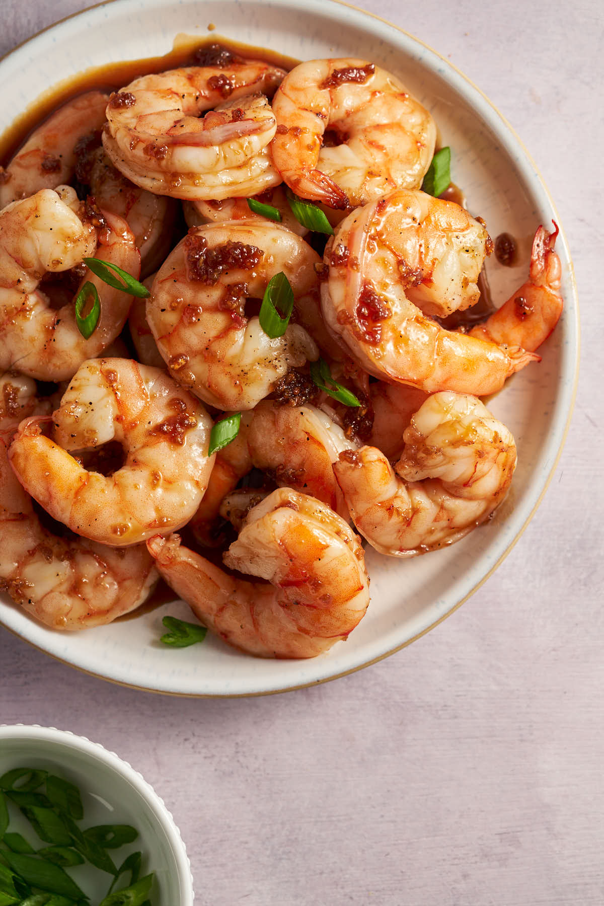 Air fryer honey garlic shrimp coated in a sweet and savory sauce and garnished with green onions