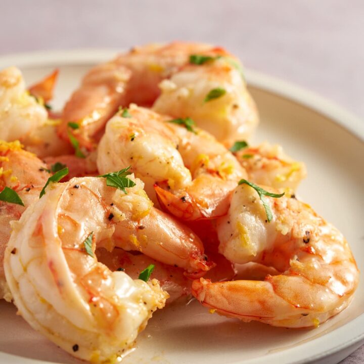 Air fryer lemon garlic shrimp served on a white plate with fresh lemon zest