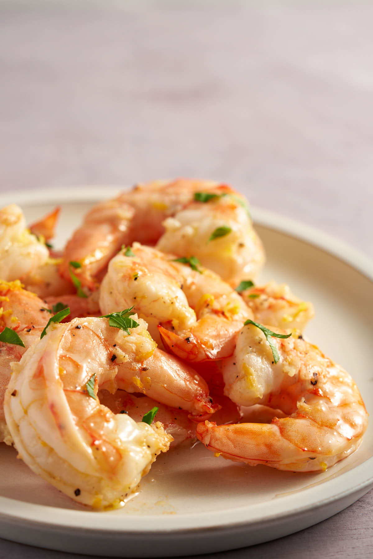 Air fryer lemon garlic shrimp served on a white plate with fresh lemon zest