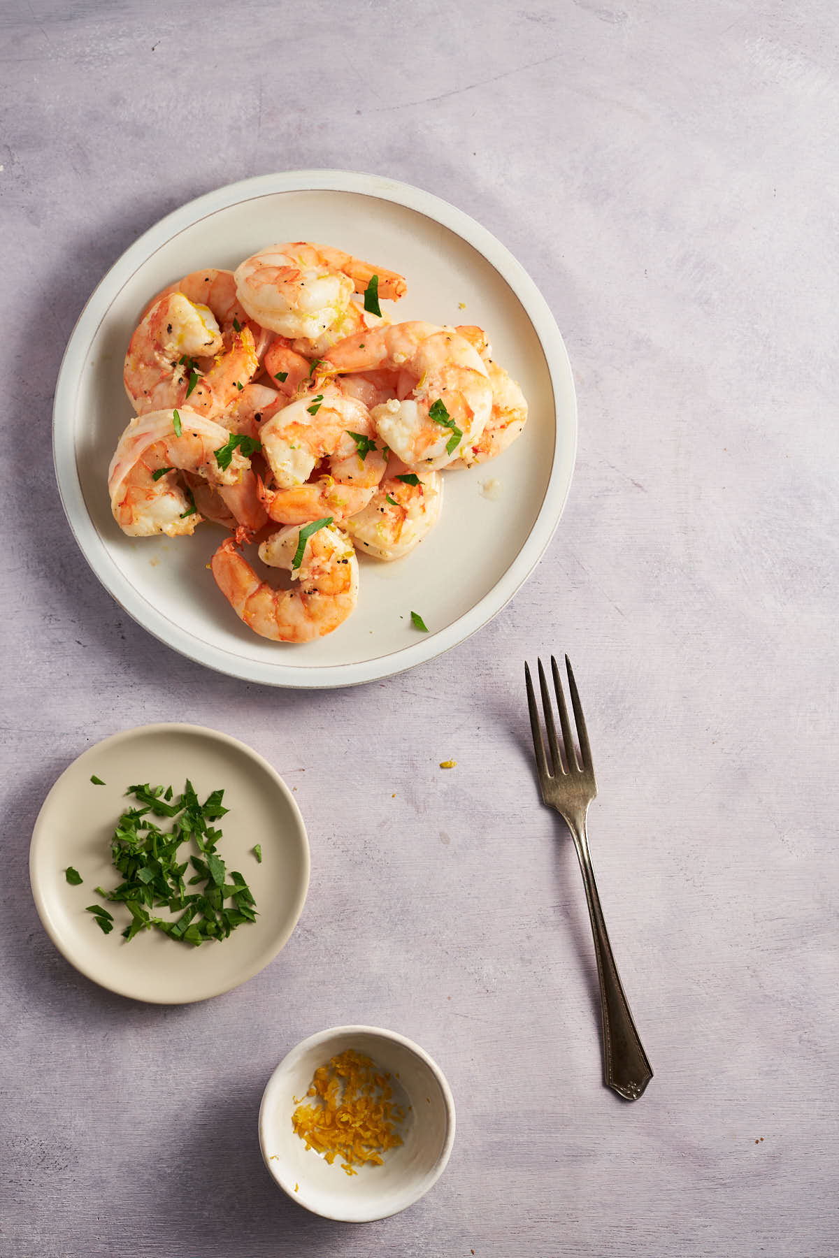 Lemon garlic shrimp cooked in the air fryer and garnished with fresh parsley and lemon zest