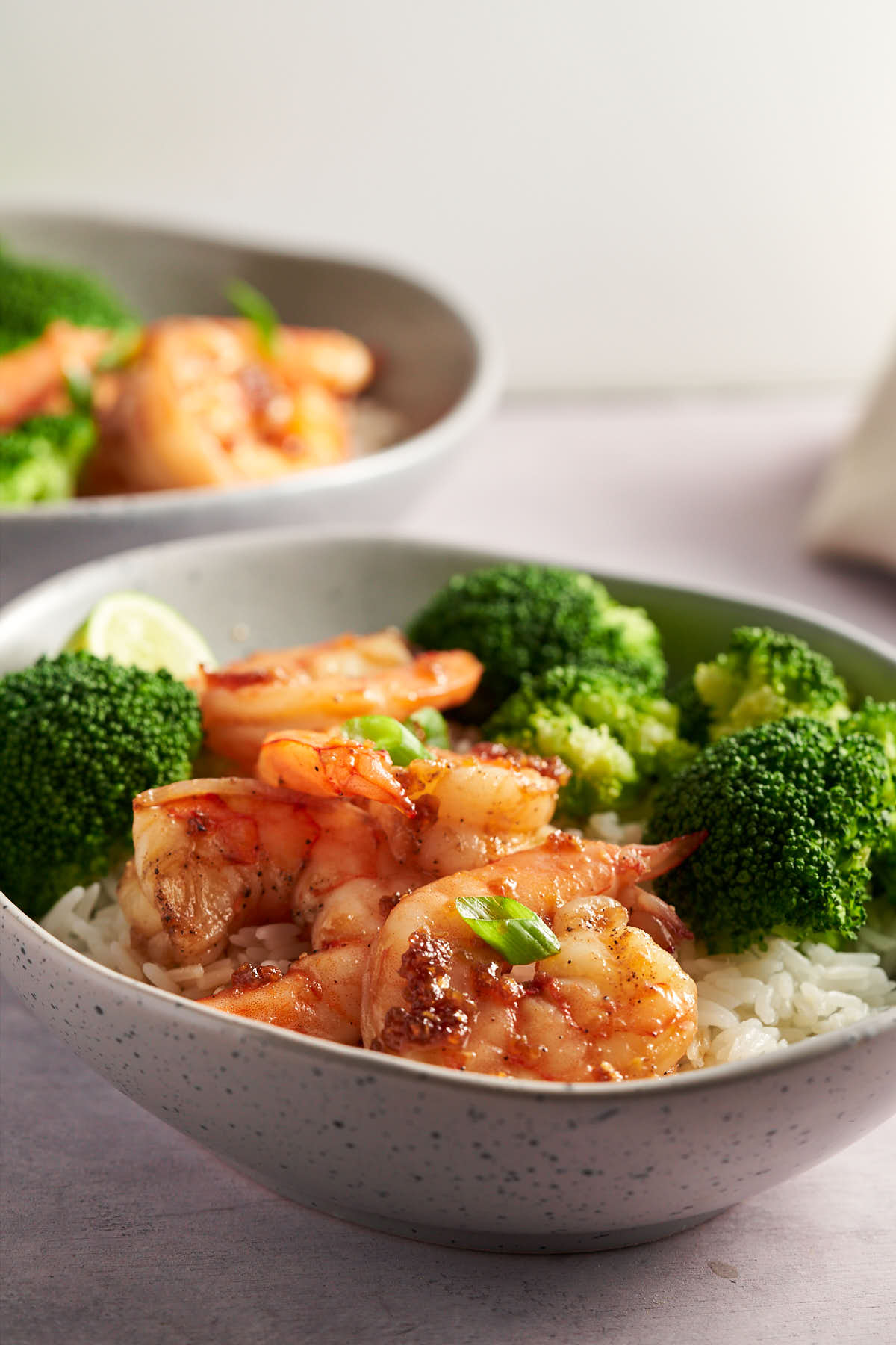 Honey garlic shrimp bowl with broccoli, rice and green onion.