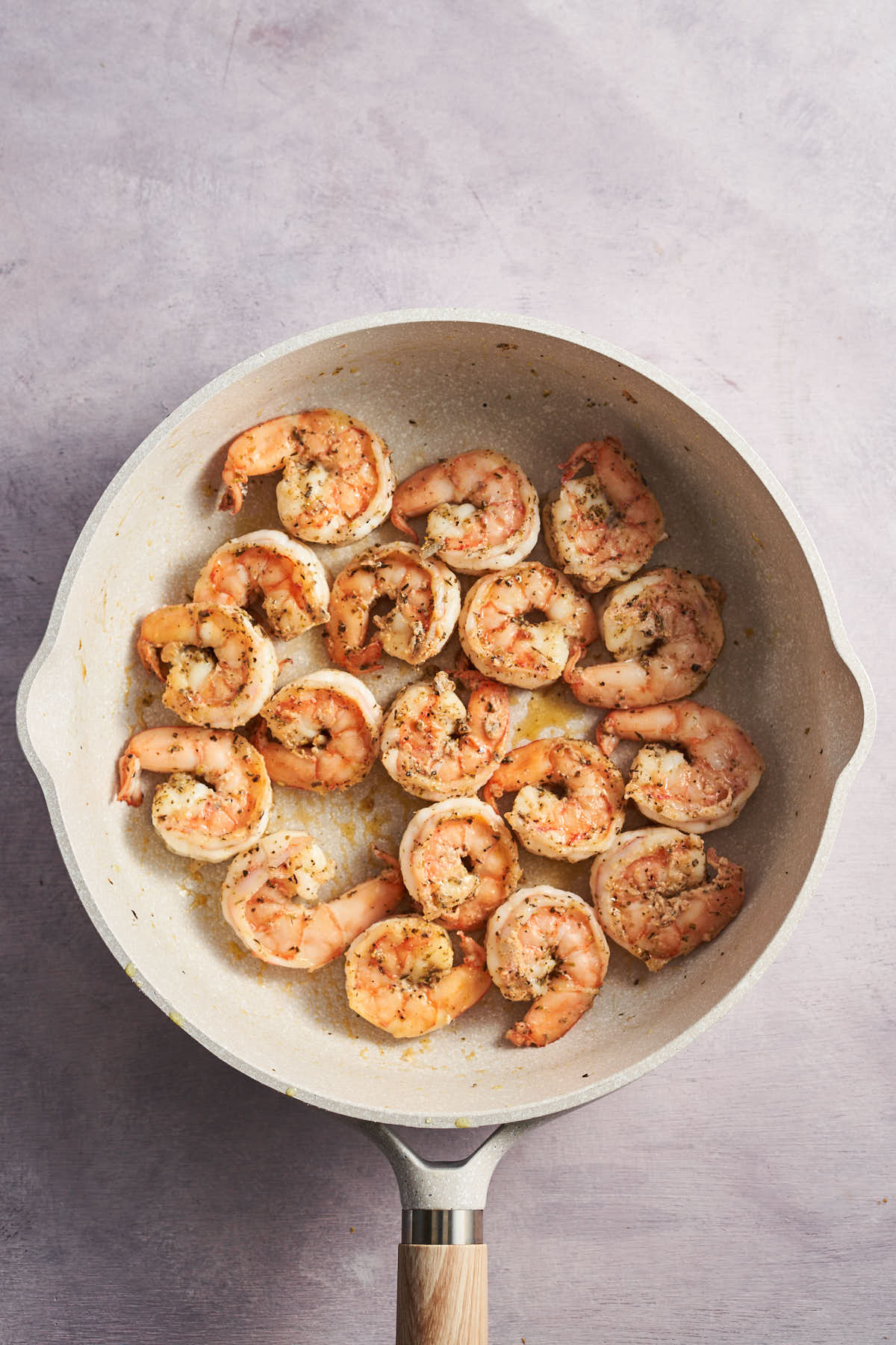 Cooked seasoned shrimp in a skillet.