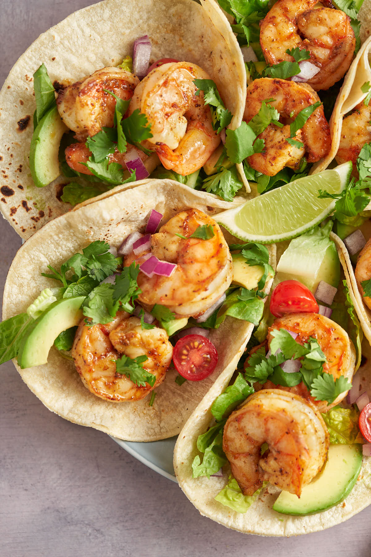 Old Bay shrimp tacos topped with cabbage and avocado.