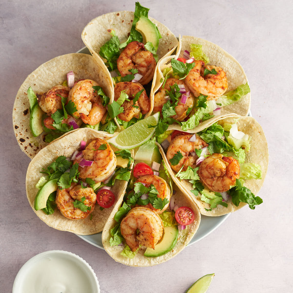 old bay shrimp tacos with lettuce, avocado and lime.